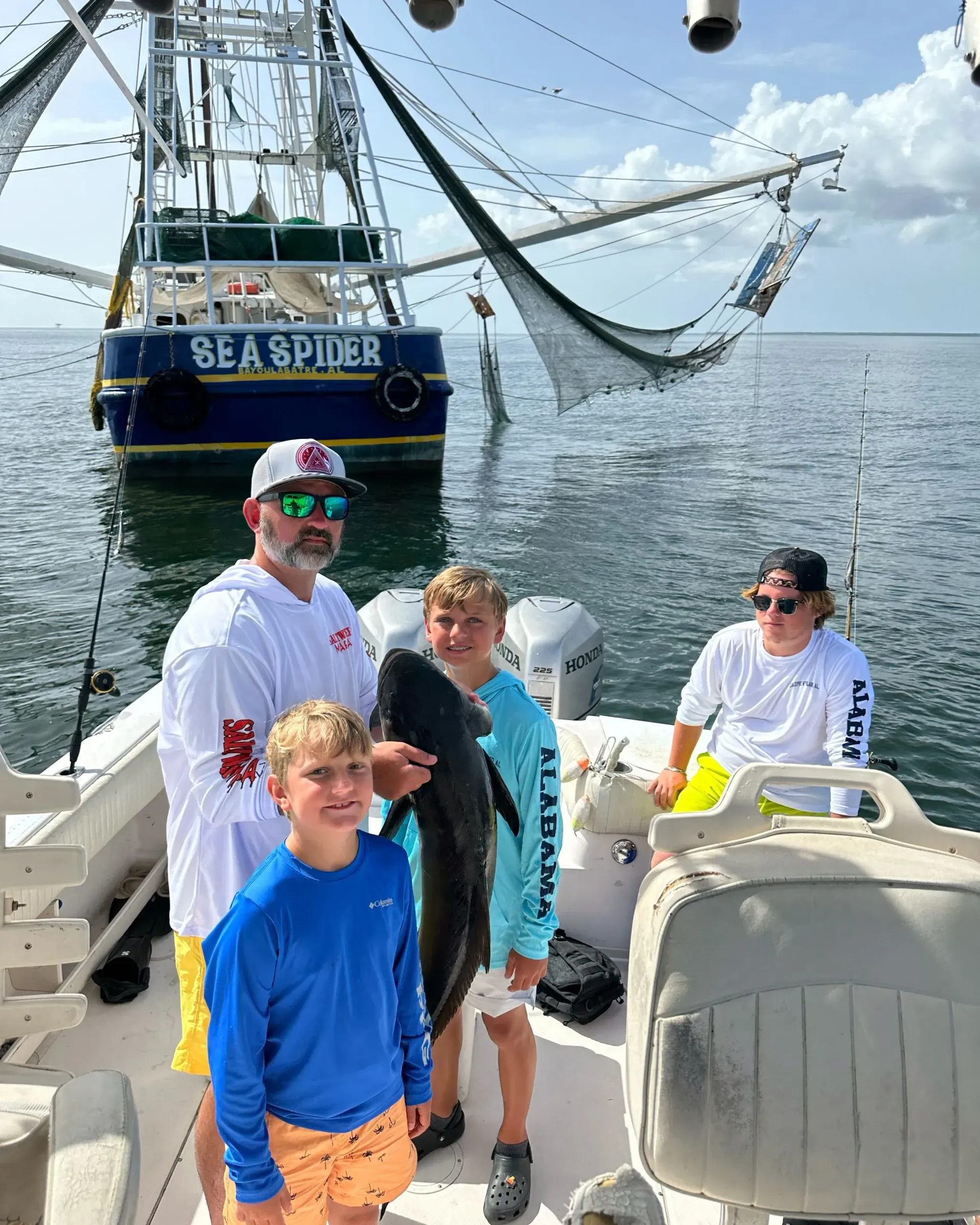 A group of people are standing on a boat with a boat in the background.