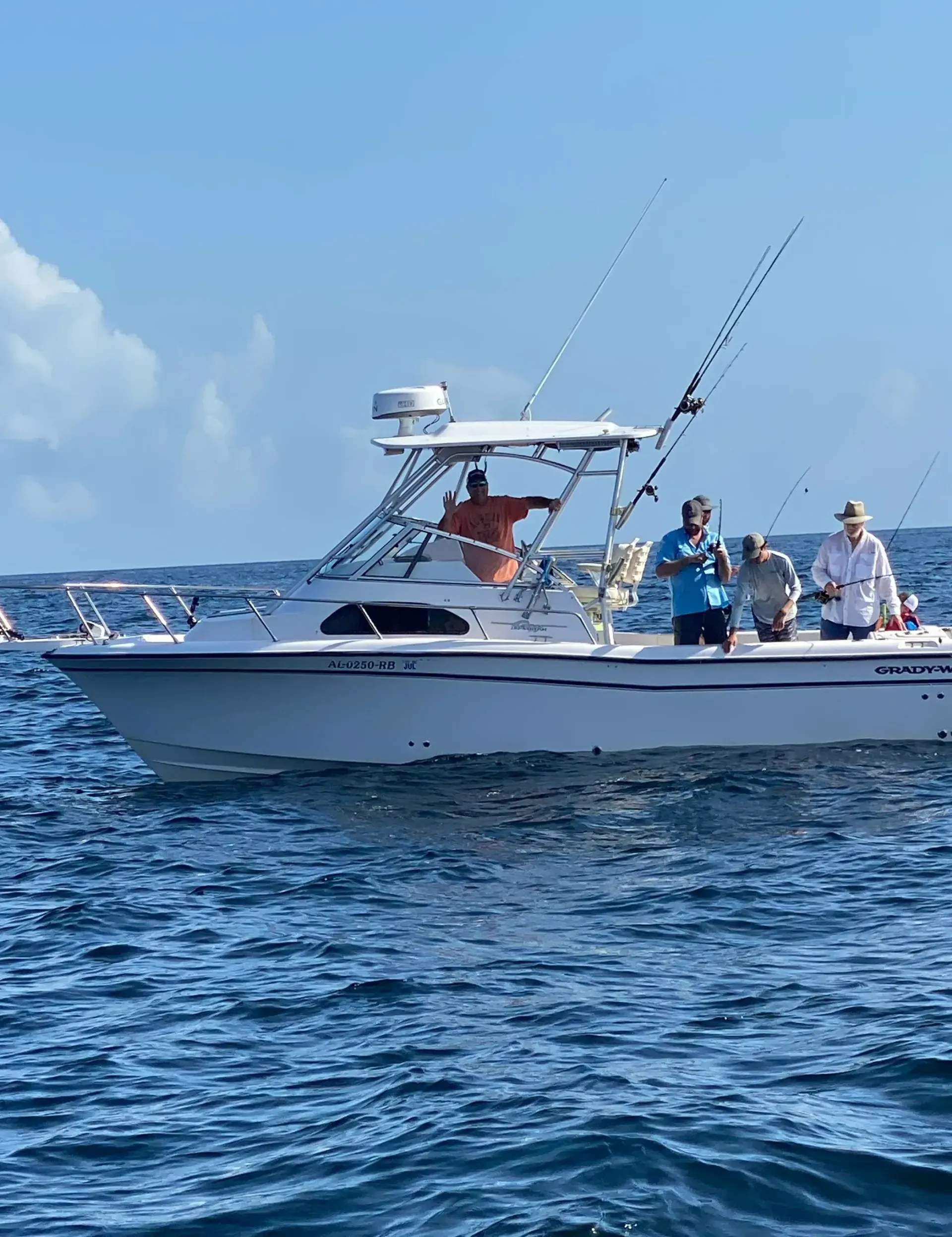 A group of people are fishing on a boat in the ocean.