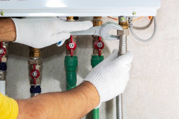 Plumber attaches gas pipe to boiler with wrench, demonstrating reliable plumber service