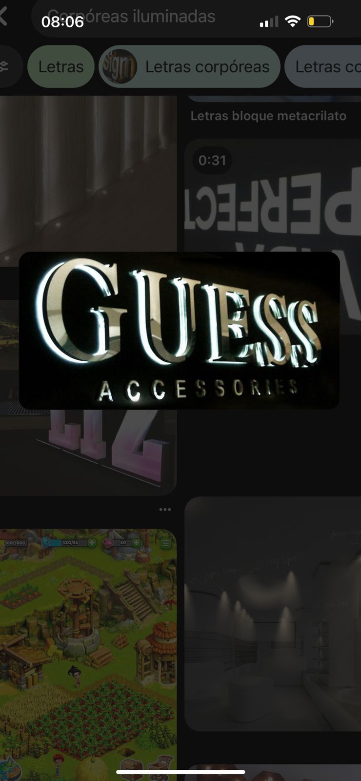 El logotipo de GUESS ACCESSORIES en la pantalla de un teléfono, rodeado de otros elementos visuales.