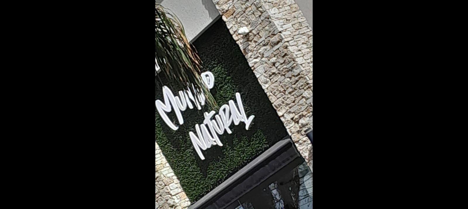 Cartel de Mani & Natural; letras blancas sobre seto verde.