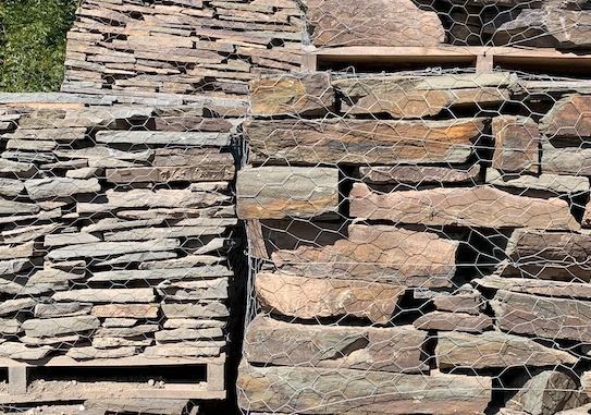 A pile of rocks stacked on top of each other behind a wire fence.