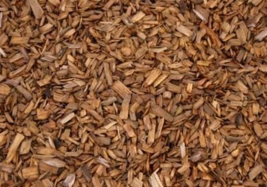 A pile of wood chips is sitting on the ground.