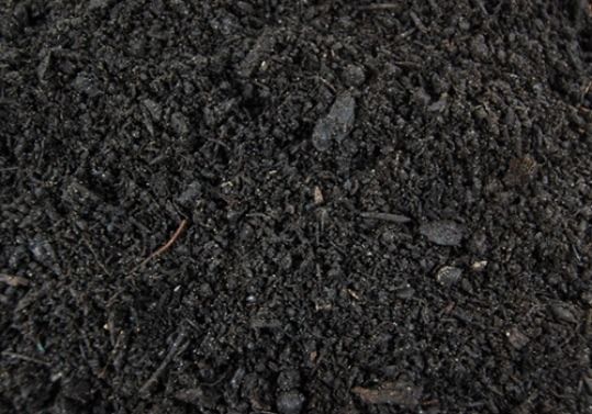 A pile of black dirt with a lot of small rocks in it.