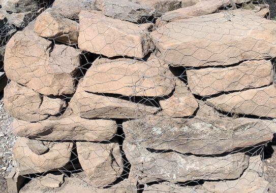A pile of rocks behind a wire fence