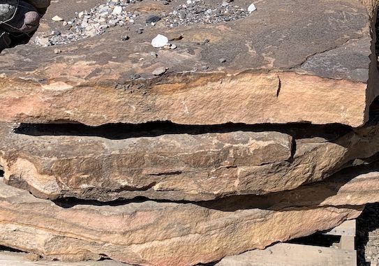 A large rock is sitting on top of a pile of rocks.