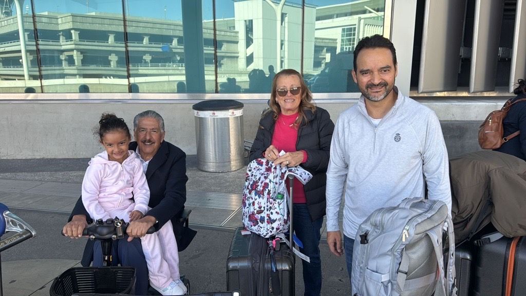 A group of people standing next to each other at an airport.