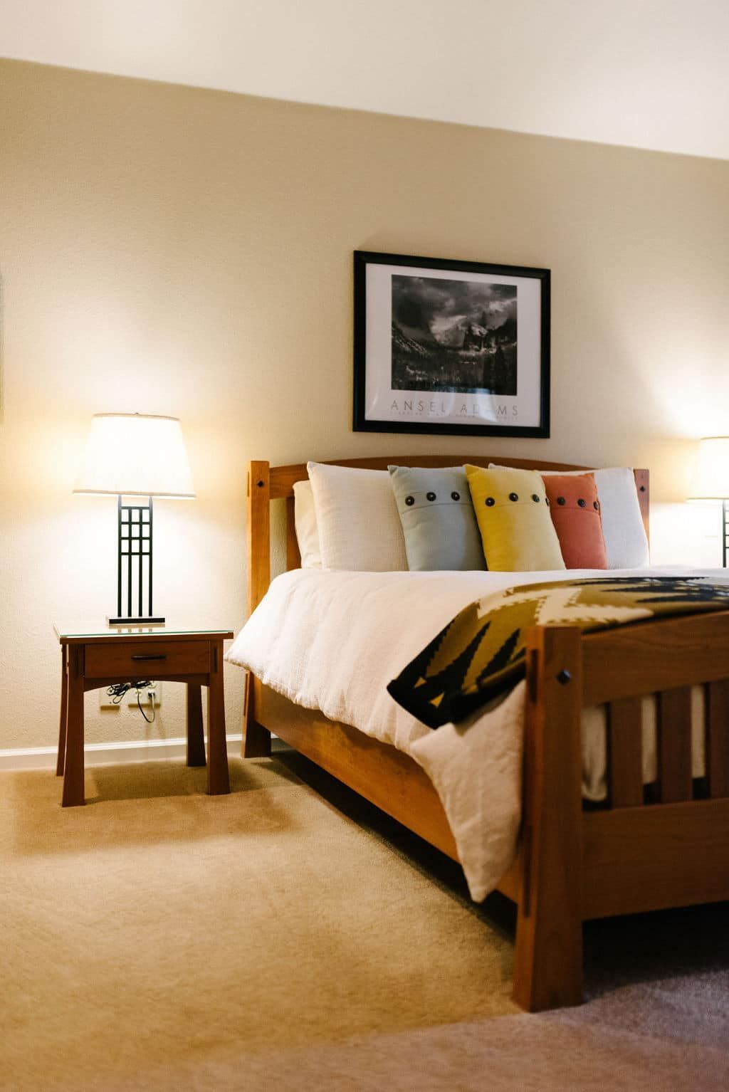 A bedroom with a large bed and a picture on the wall above it