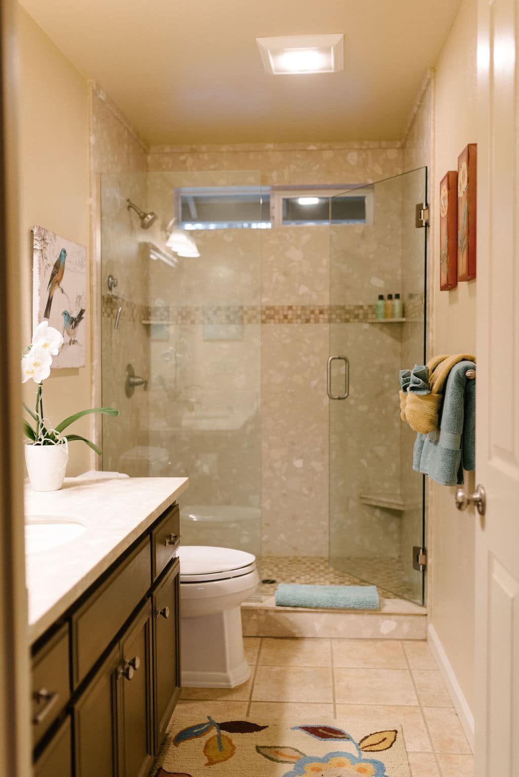 A bathroom with a toilet , sink , and walk in shower.