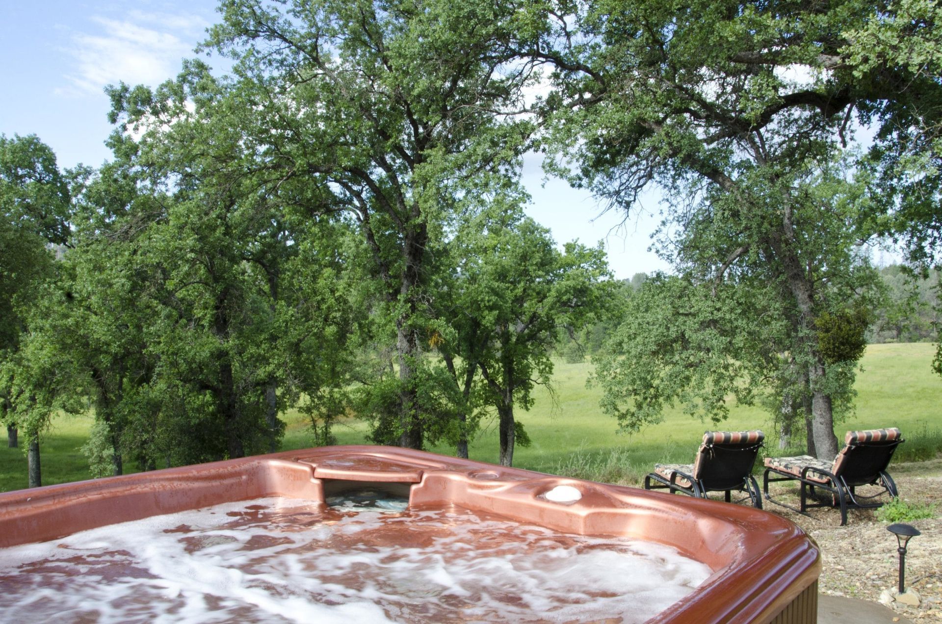 A hot tub with a view of a field and trees
