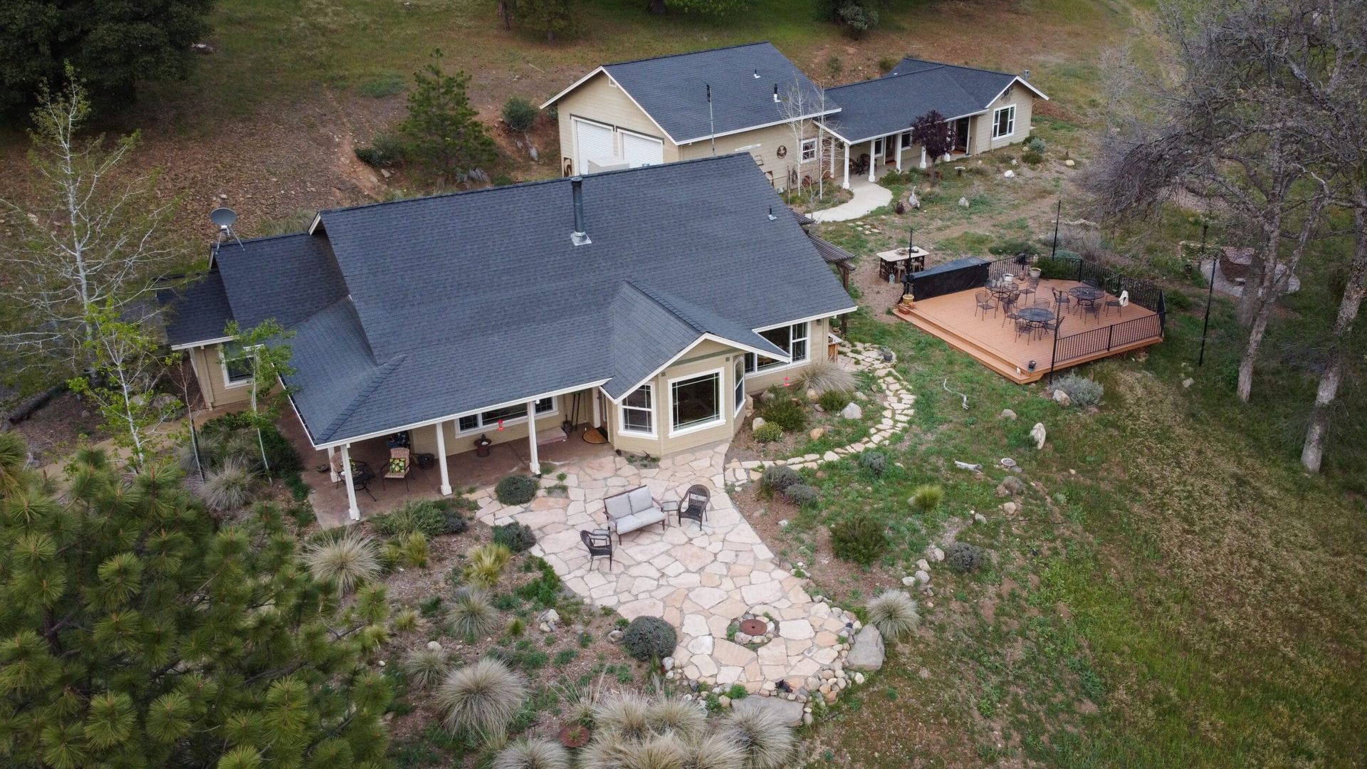 An aerial view of a large house in the middle of a lush green field.