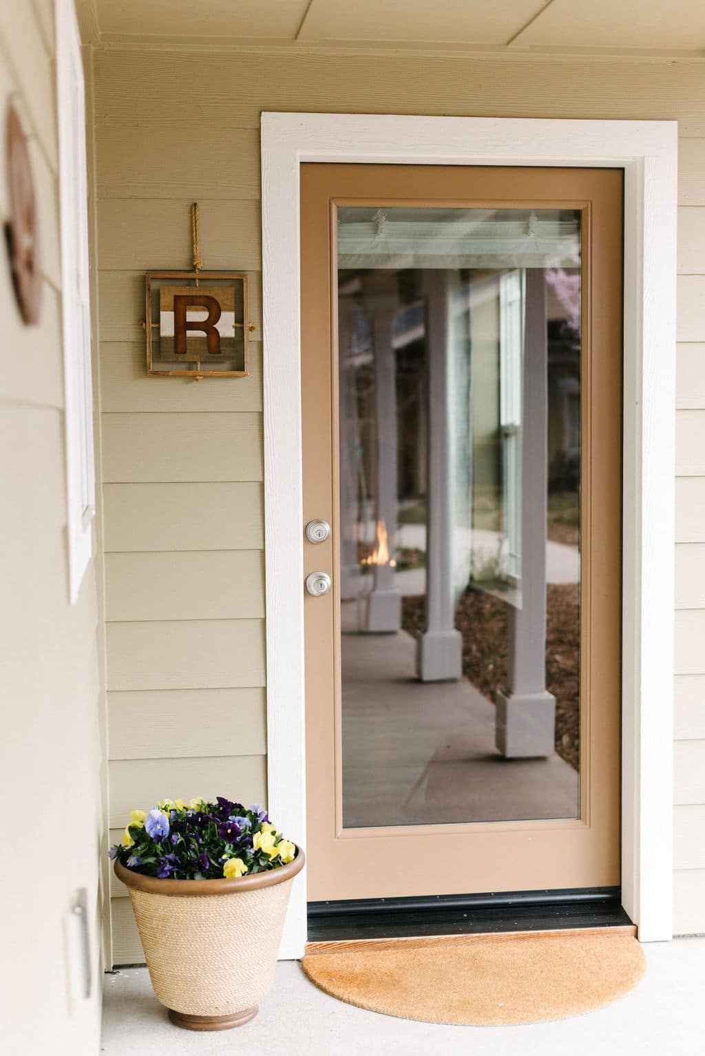 The front door of a house with a potted plant in front of it.