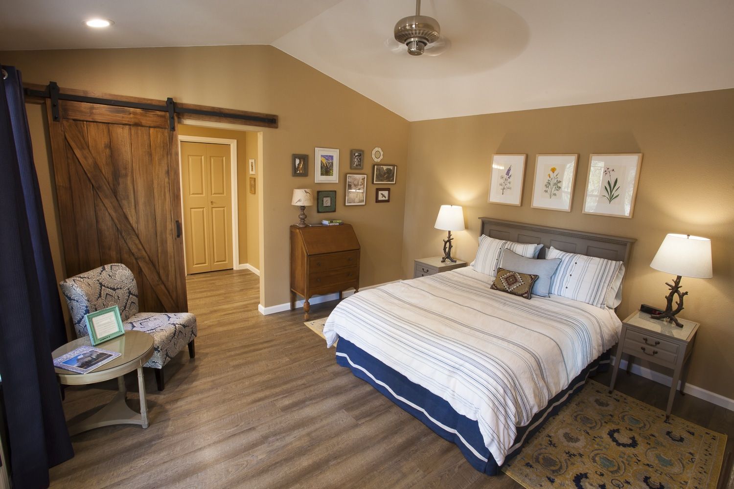 A bedroom with a king size bed and a sliding barn door.
