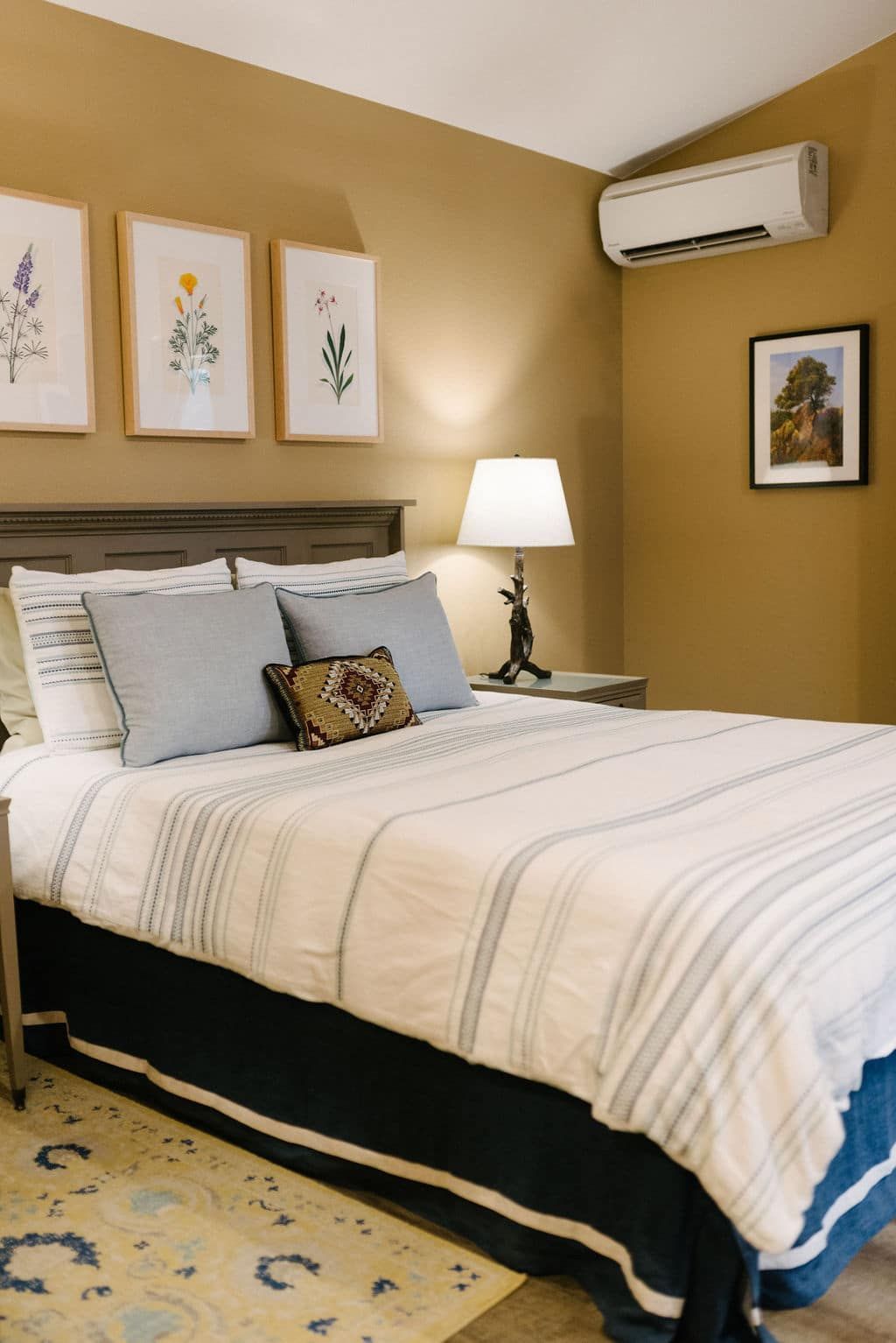 A bedroom with a king size bed and a lamp.