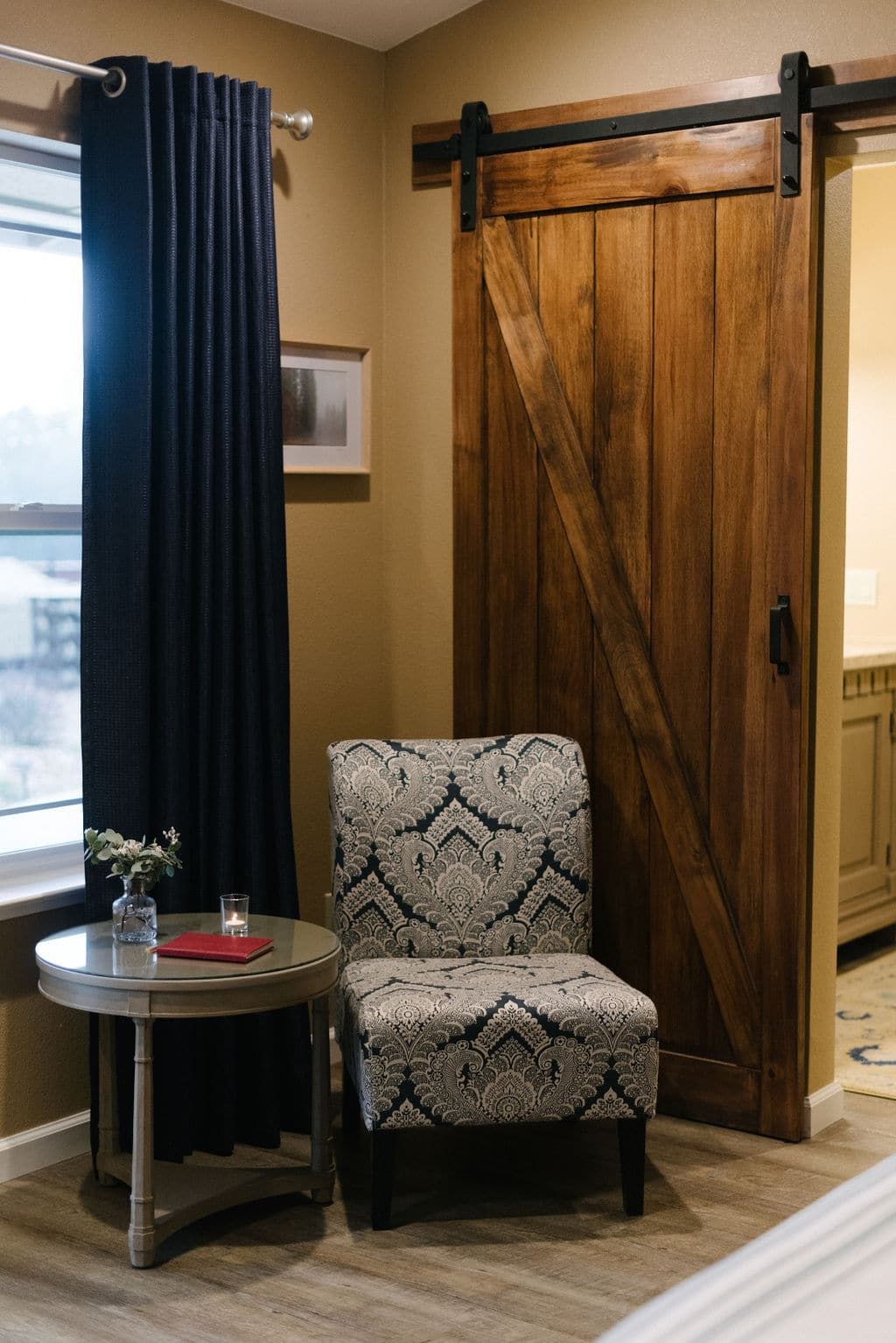 A chair and a table in a room with a sliding barn door.