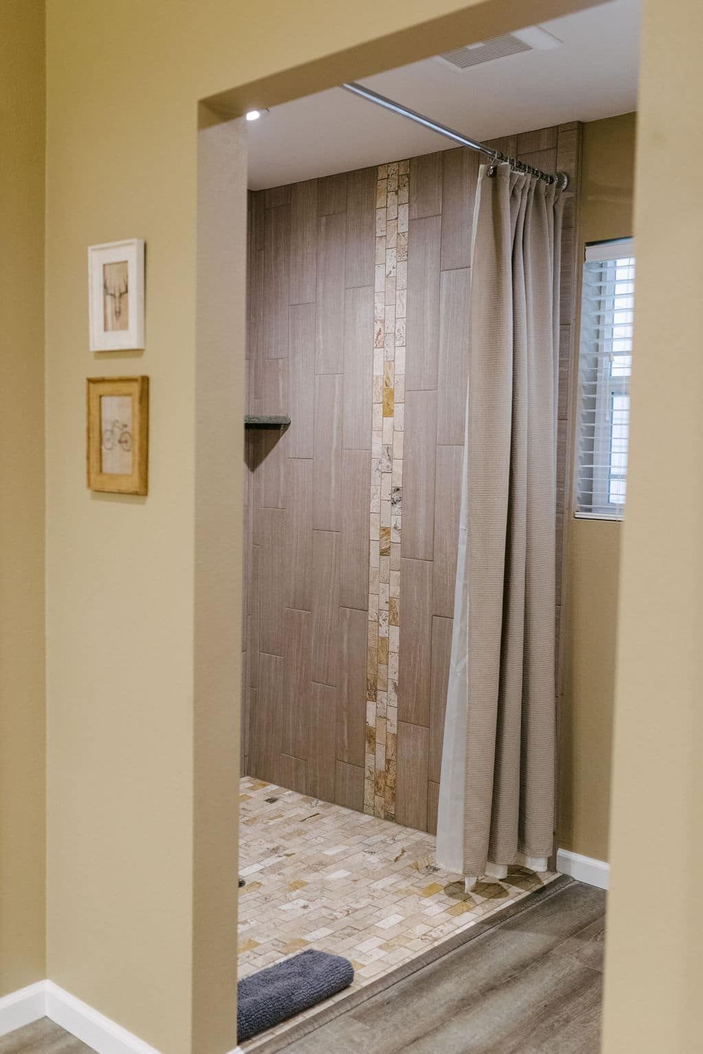 A bathroom with a walk in shower and a window.