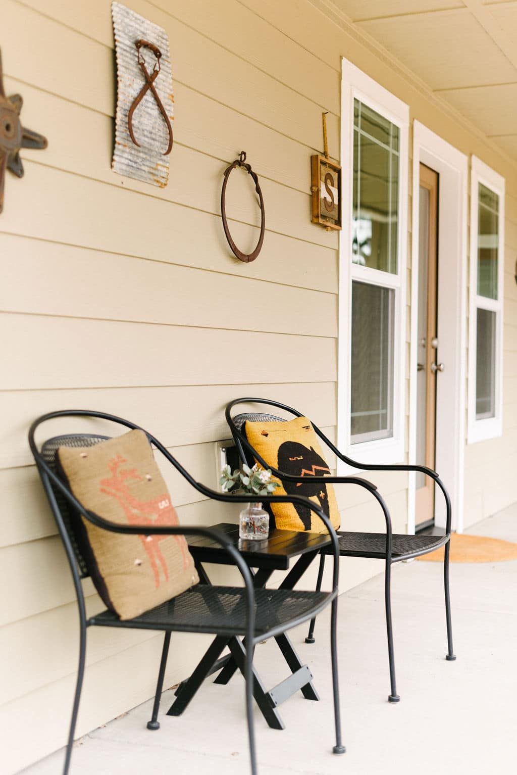 Two chairs and a table on a porch with the number 8 on the wall