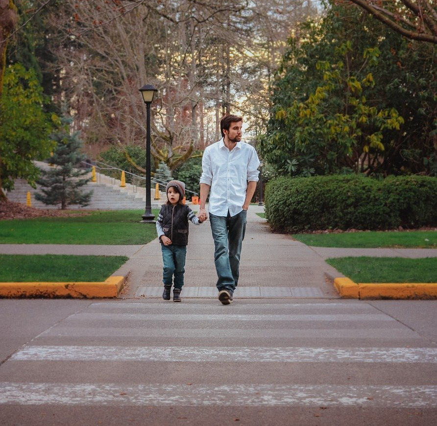 The first image is of cracked asphalt. The second image is of a father and son walking across a crosswalk on a crisp autumn afternoon.