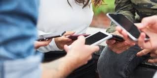 People holding and using smartphones; hands and screens are visible.