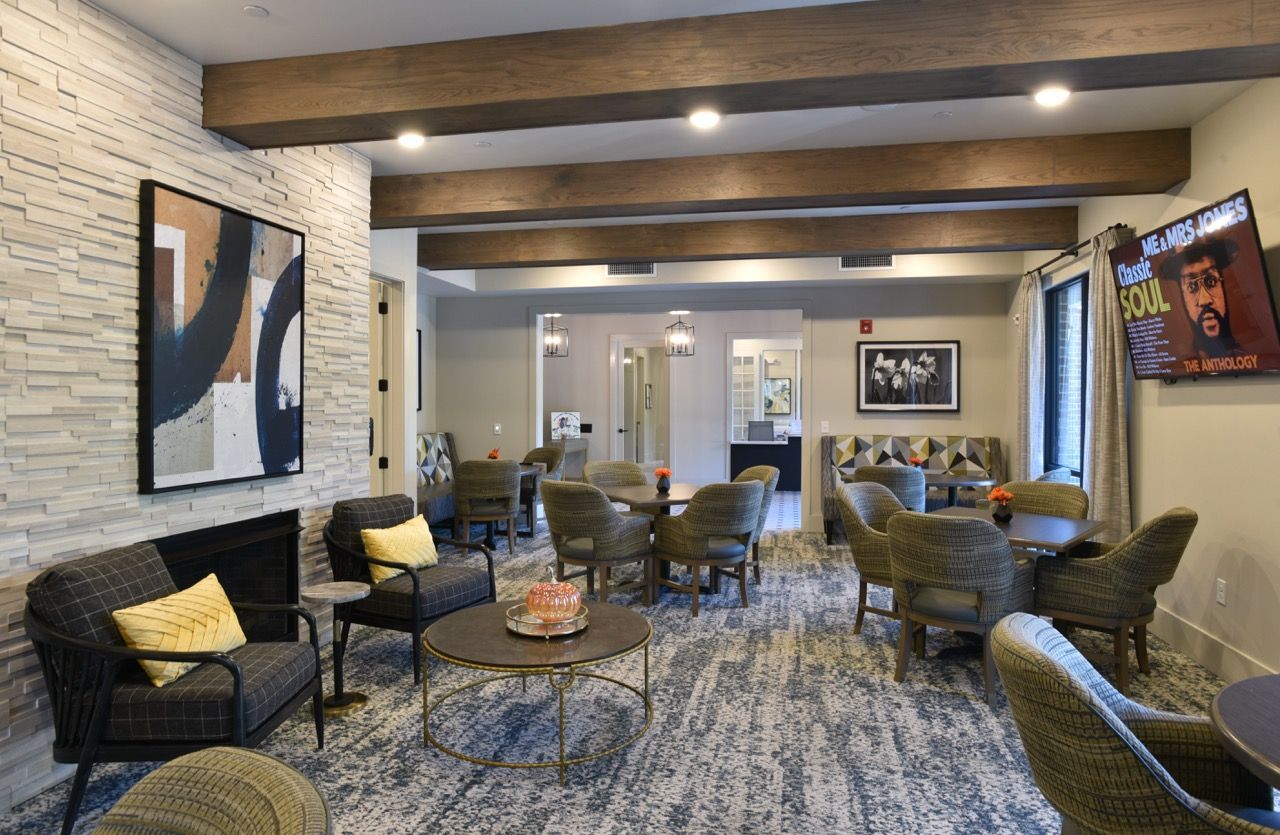 Interior of a modern resident lounge with couches, armchairs, and tables.