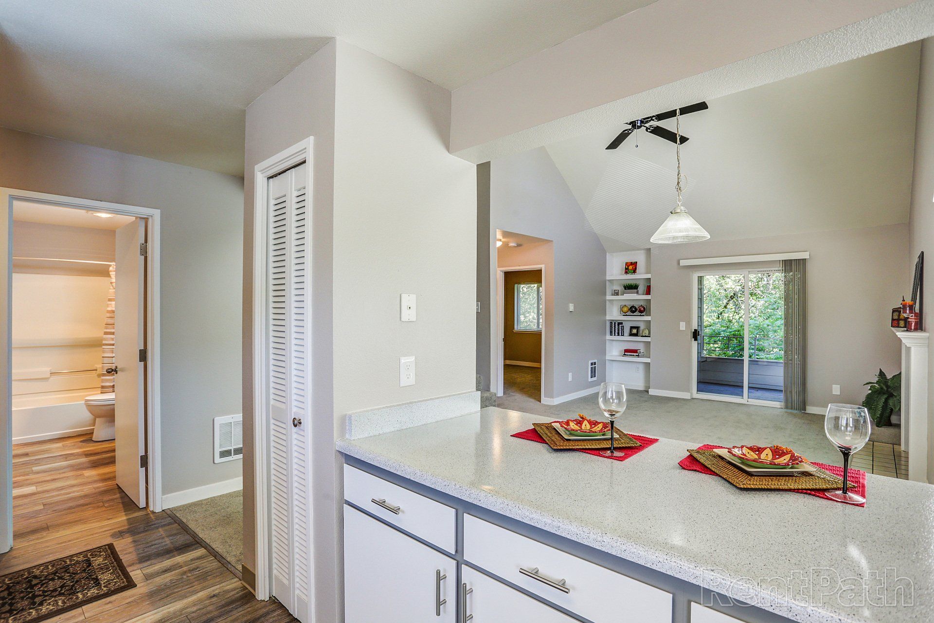 A kitchen with a counter top and a dining room in the background.