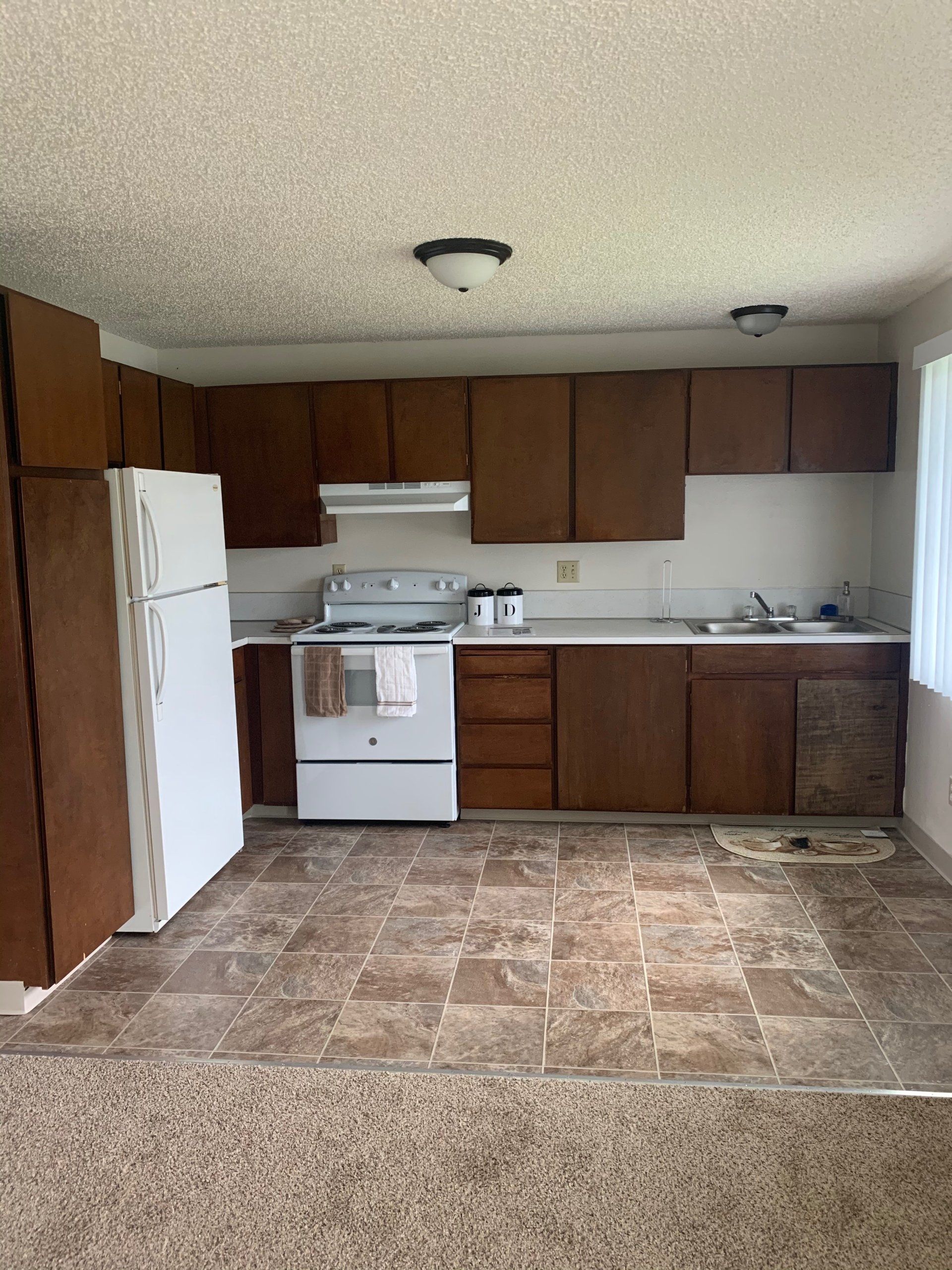 A kitchen with brown cabinets and a white refrigerator