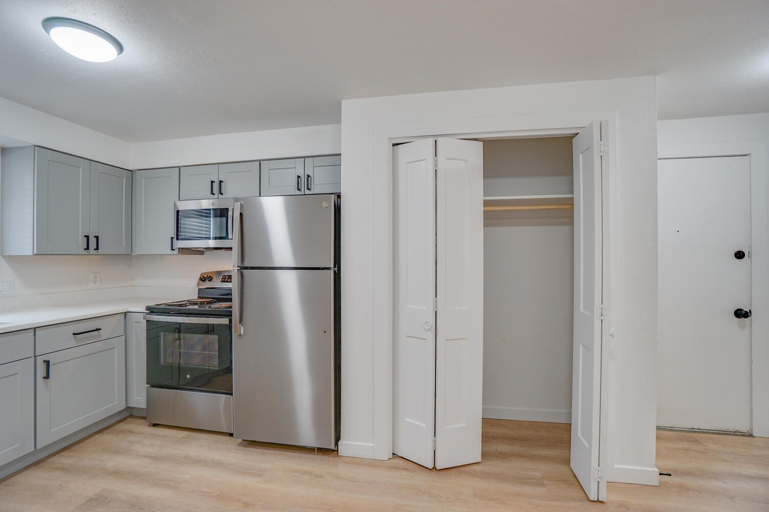 A kitchen with stainless steel appliances and white cabinets