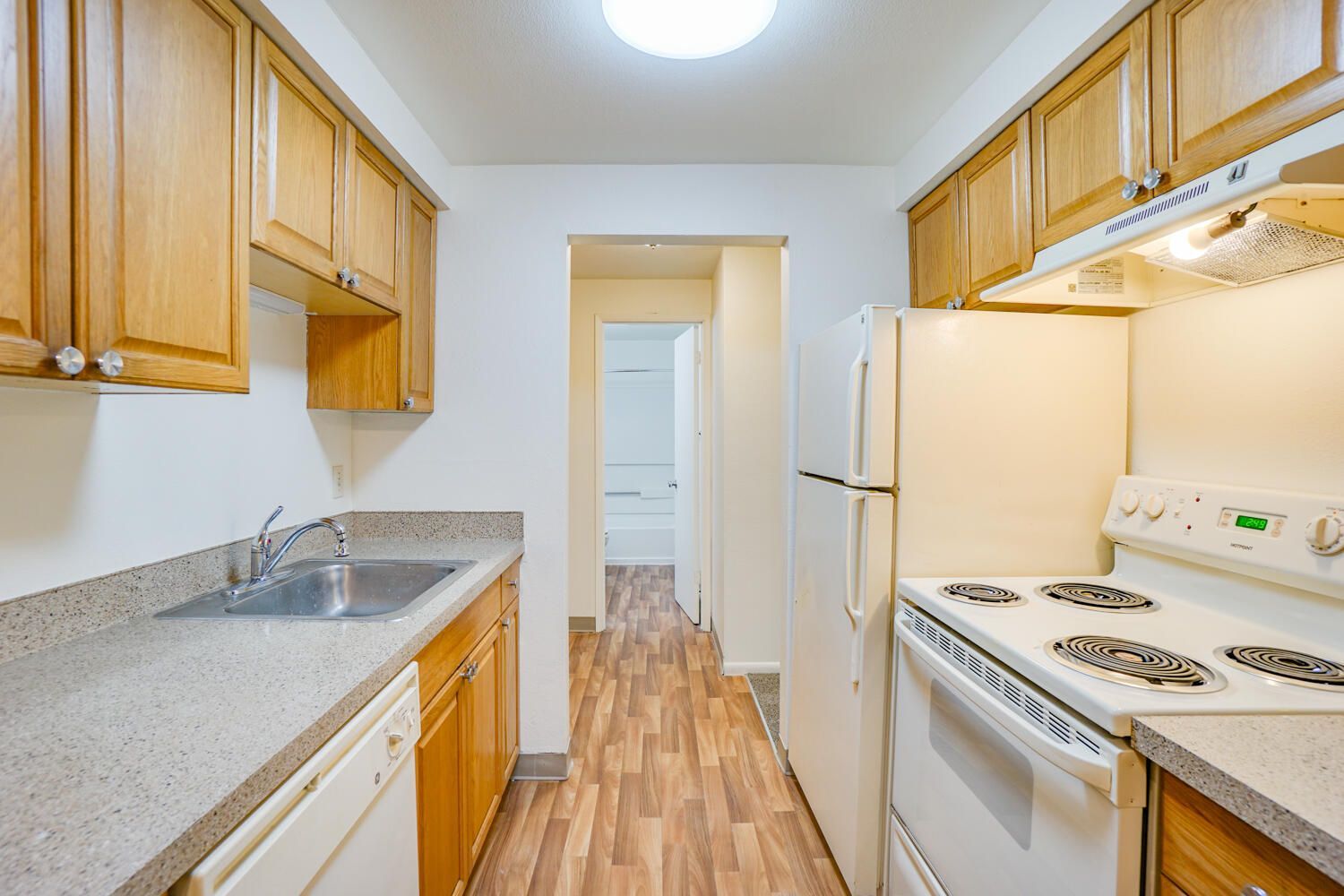A kitchen with a stove , refrigerator , sink and dishwasher
