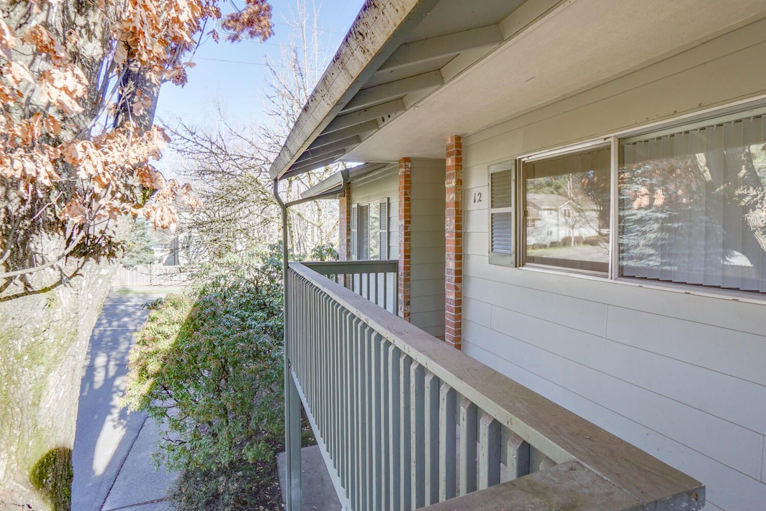 A balcony on the side of a building with a tree in the background.
