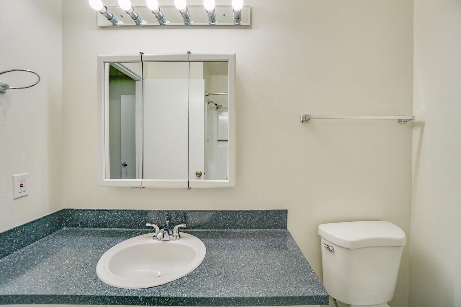 A bathroom with a sink , toilet and mirror.