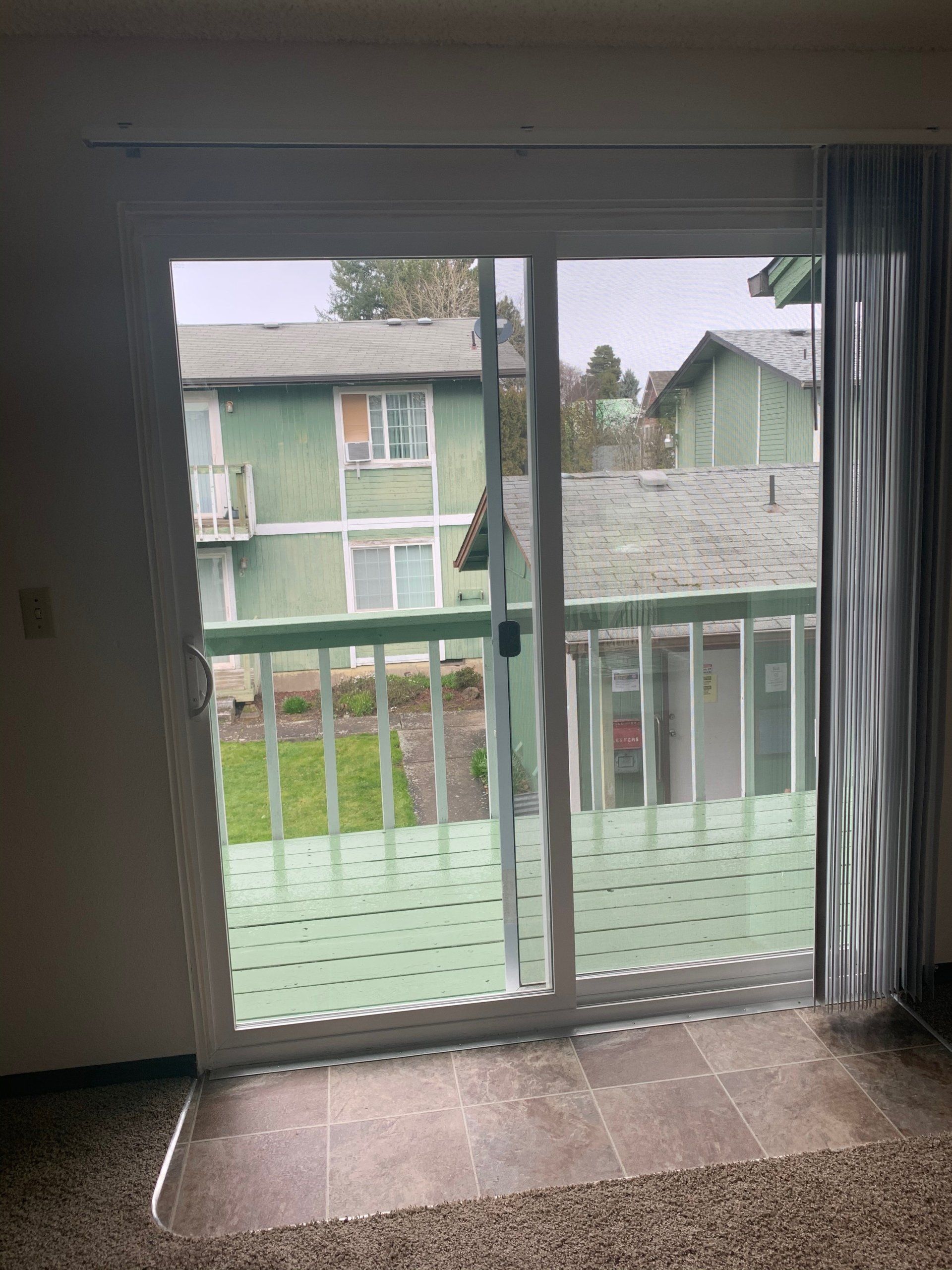A living room with a sliding glass door leading to a balcony.