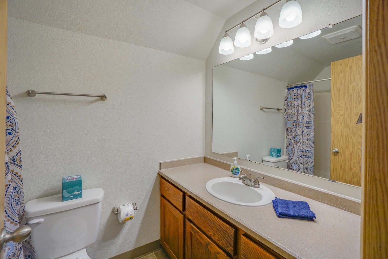 A bathroom with a toilet , sink , and mirror.