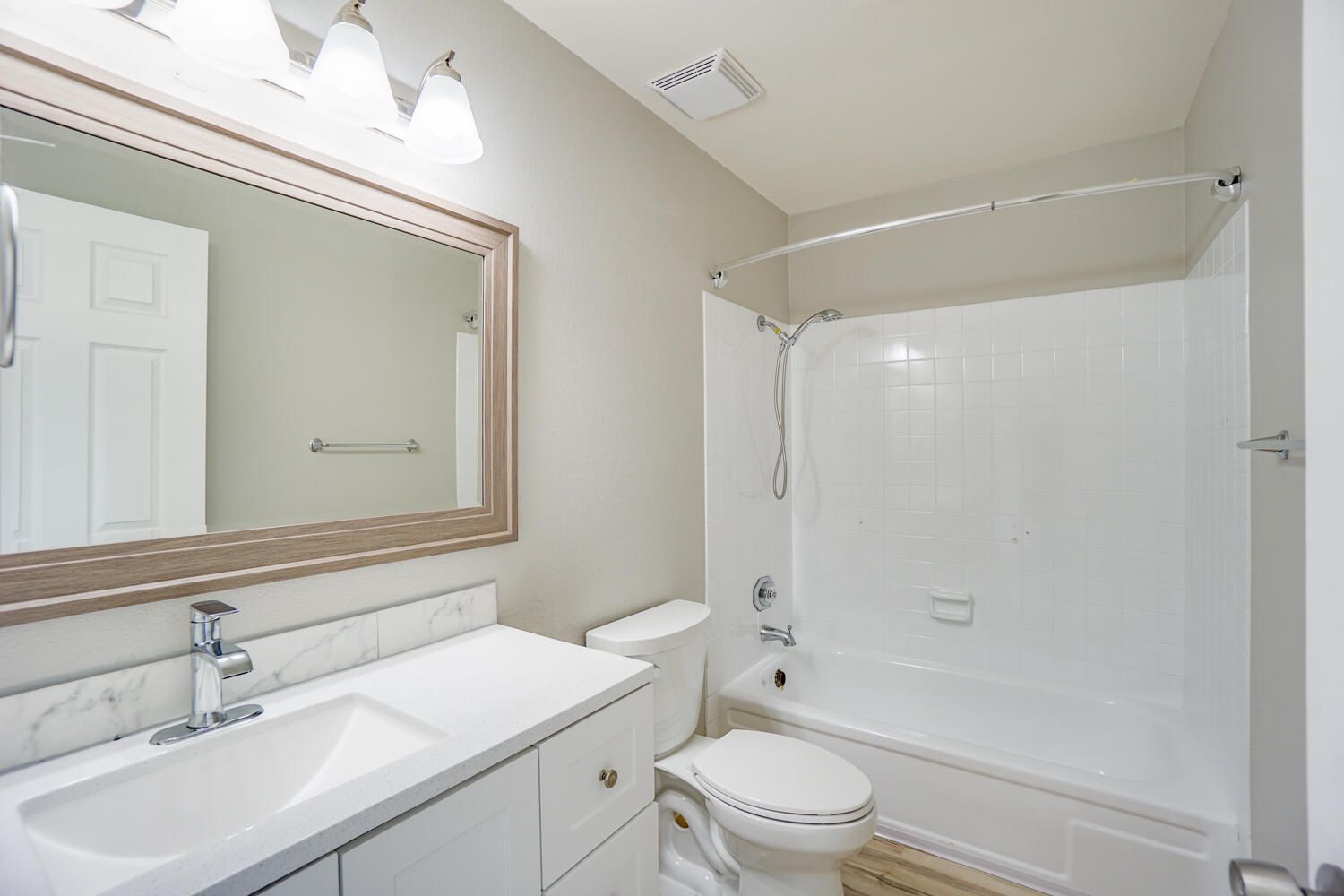 A bathroom with a toilet , sink , and bathtub.