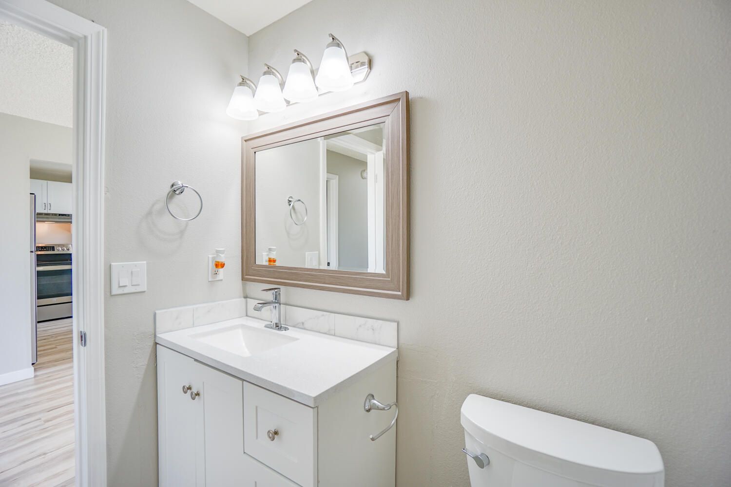 A bathroom with a sink , toilet and mirror.
