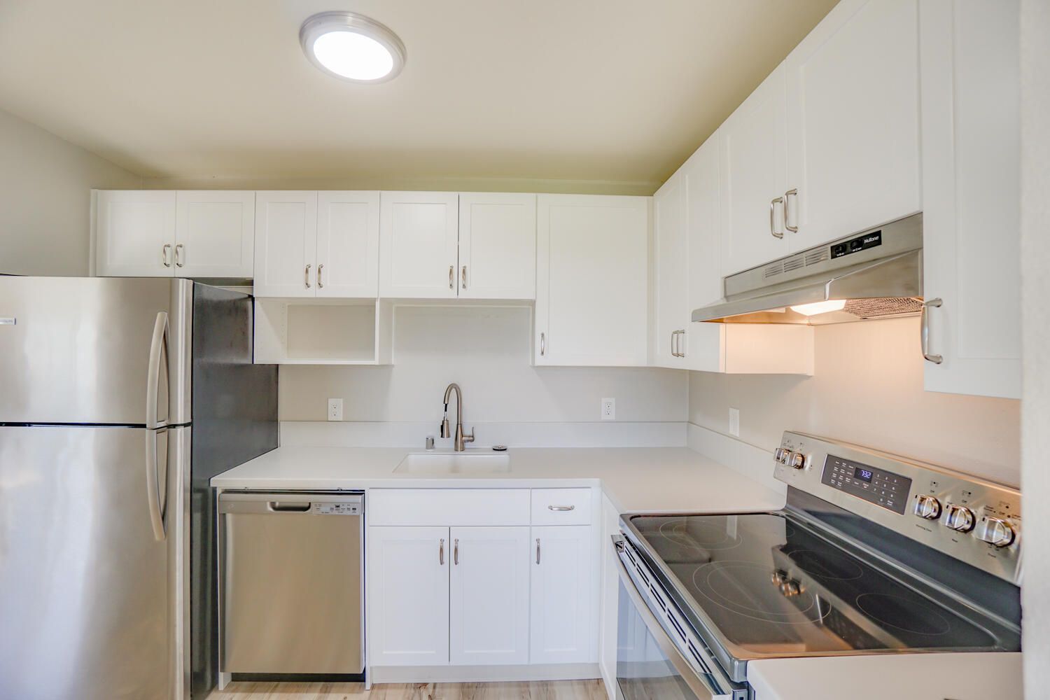A kitchen with white cabinets and stainless steel appliances