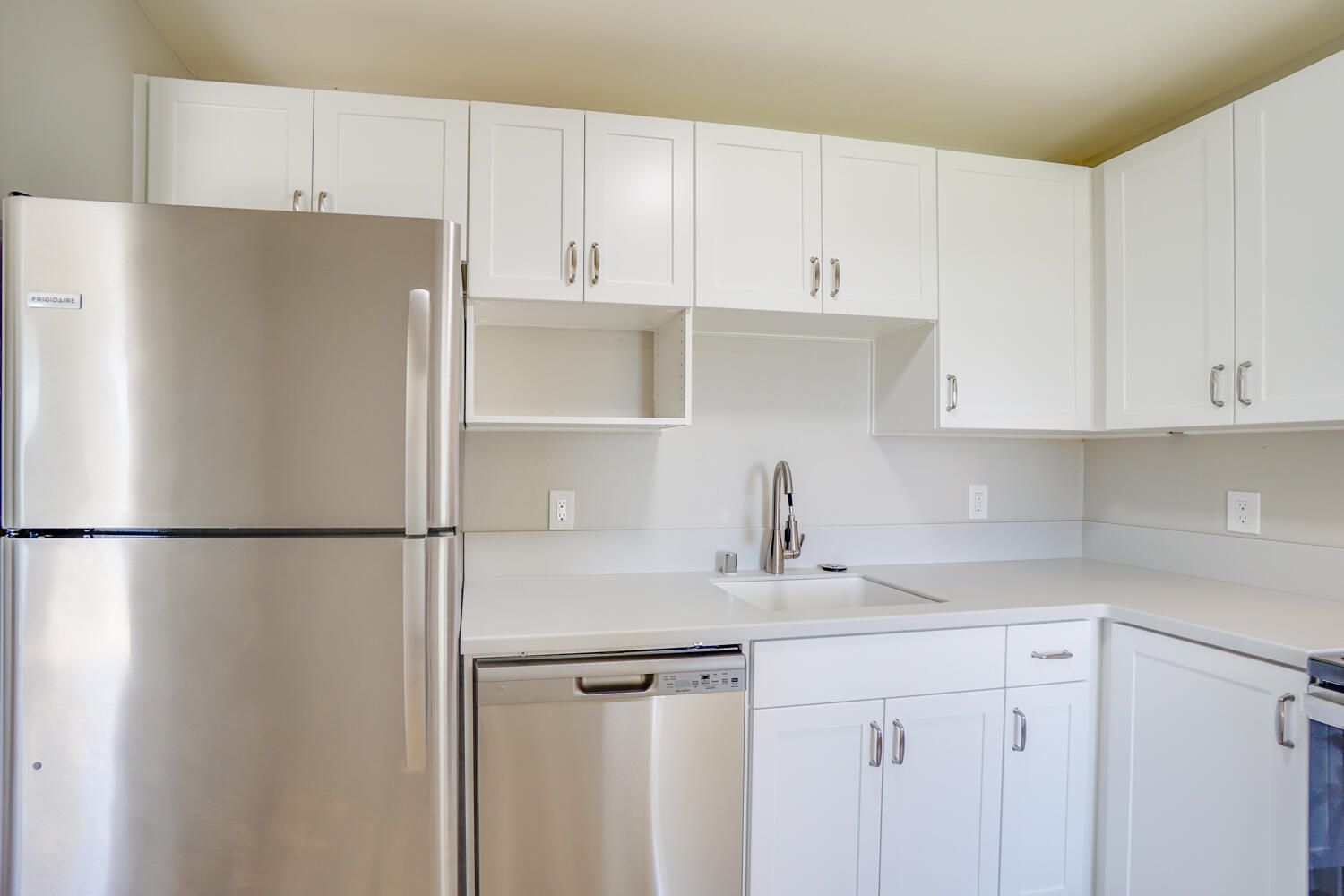 A kitchen with stainless steel appliances and white cabinets