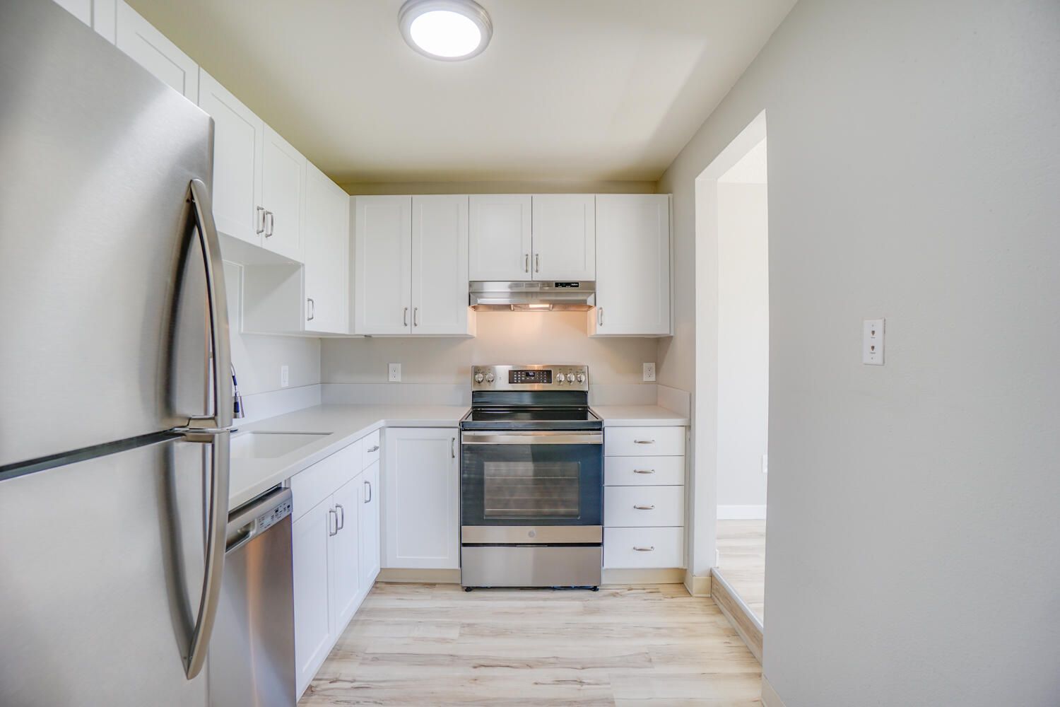 A kitchen with white cabinets and stainless steel appliances