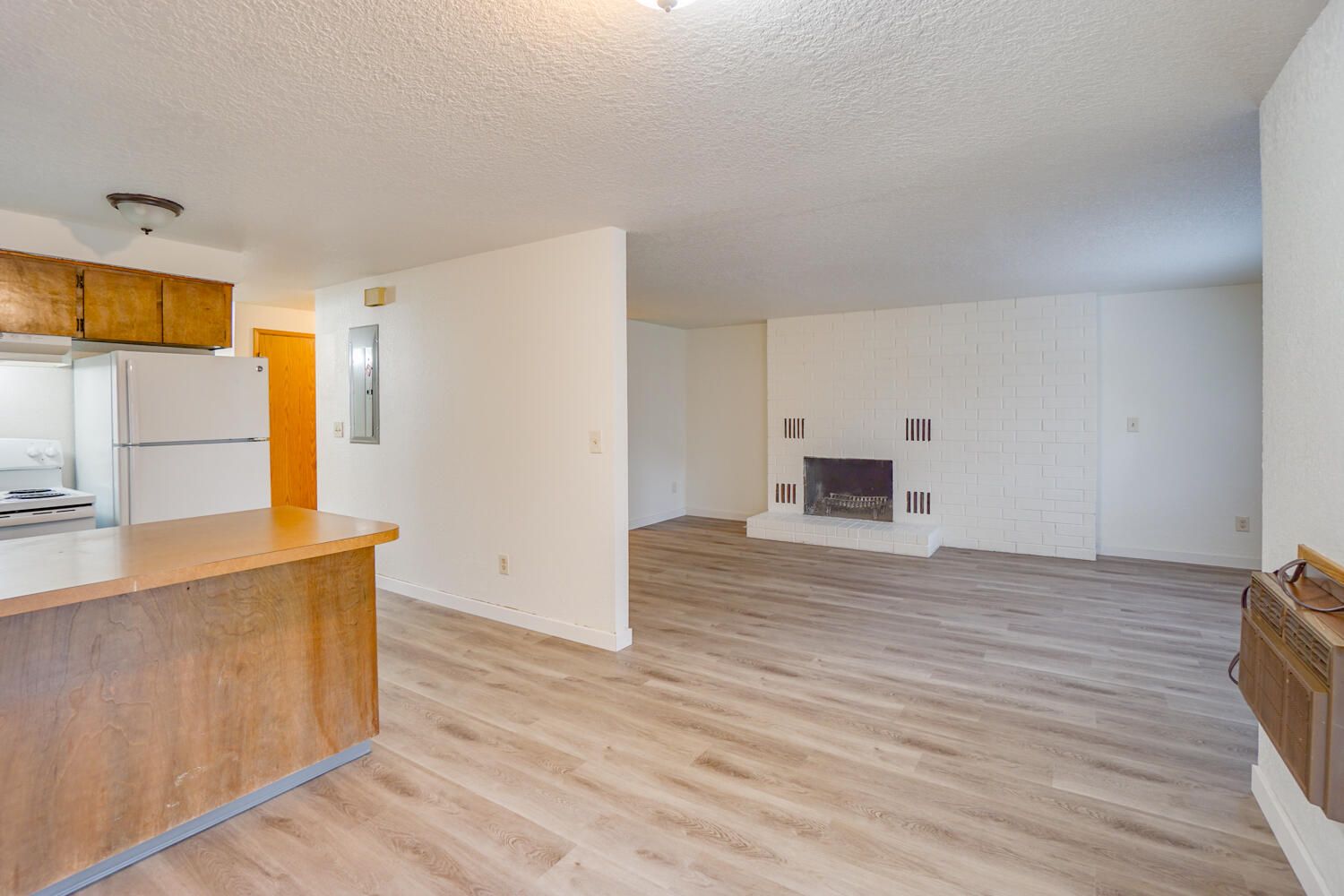 A living room with hardwood floors and a fireplace.