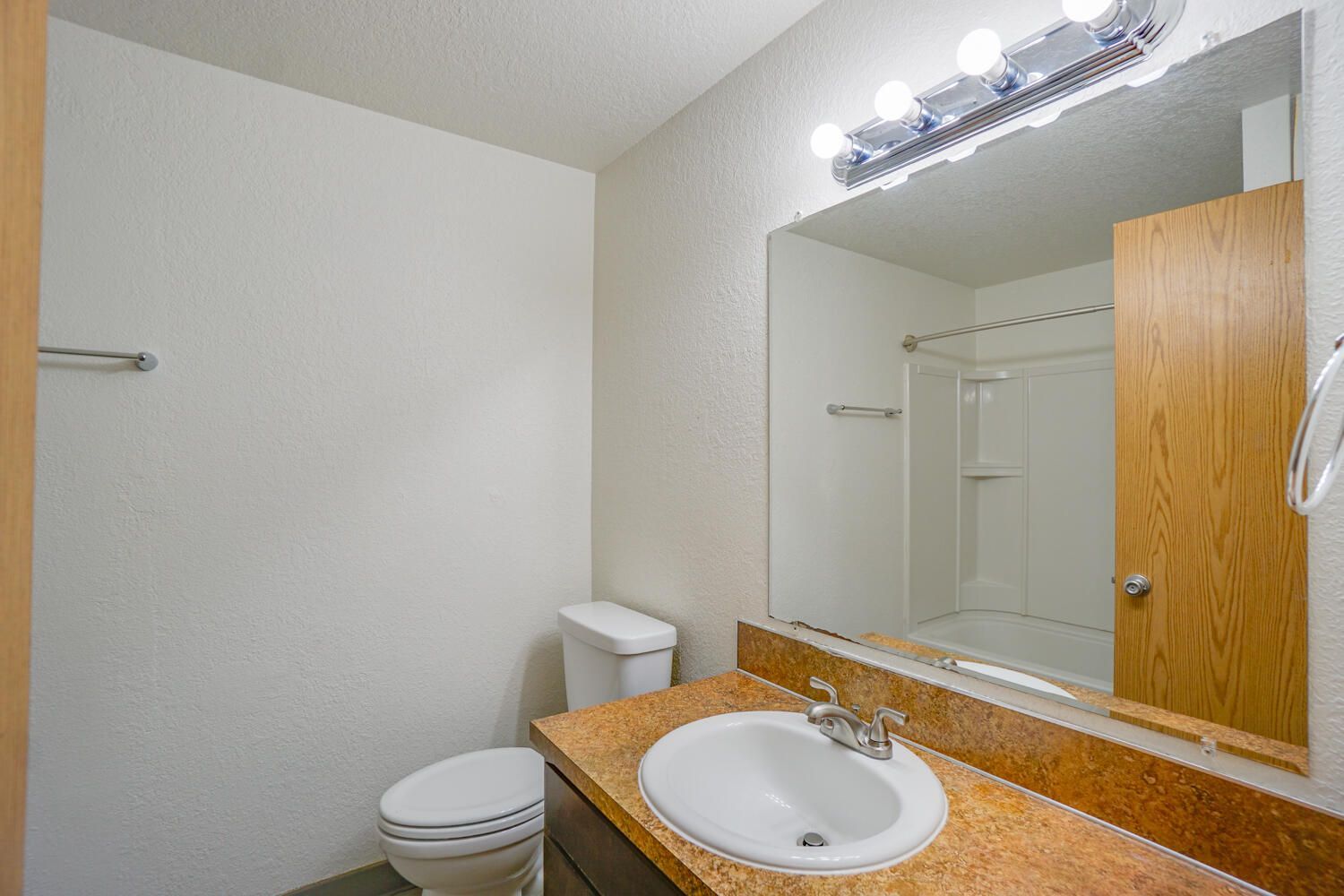 A bathroom with a toilet , sink , and mirror.