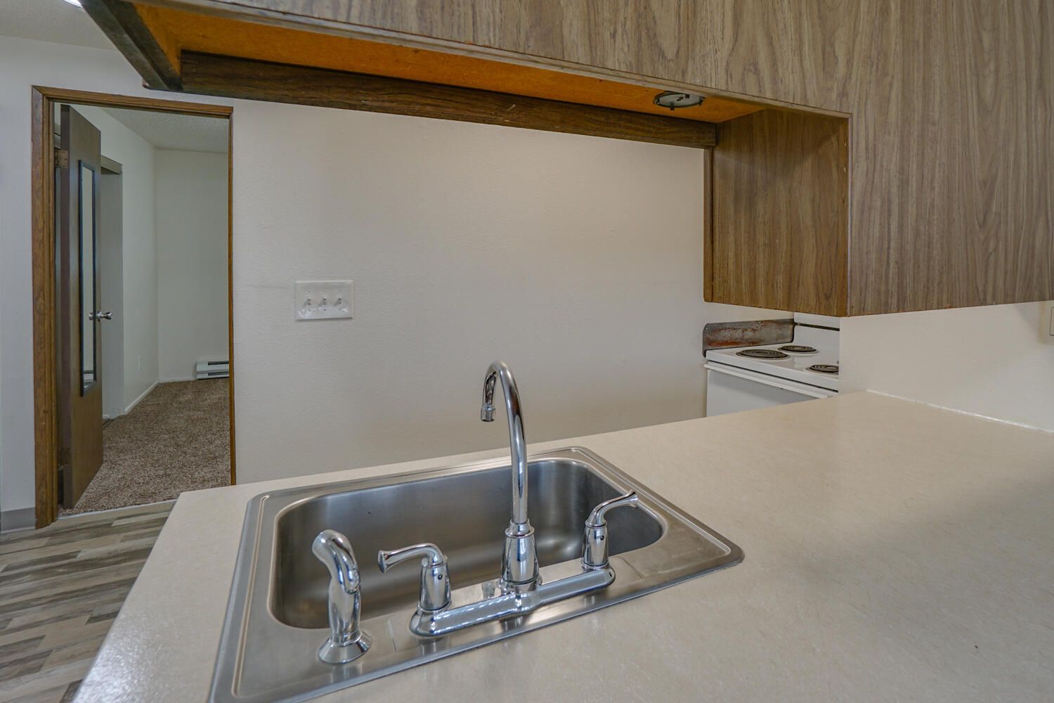 A kitchen sink is sitting on a counter in a kitchen.