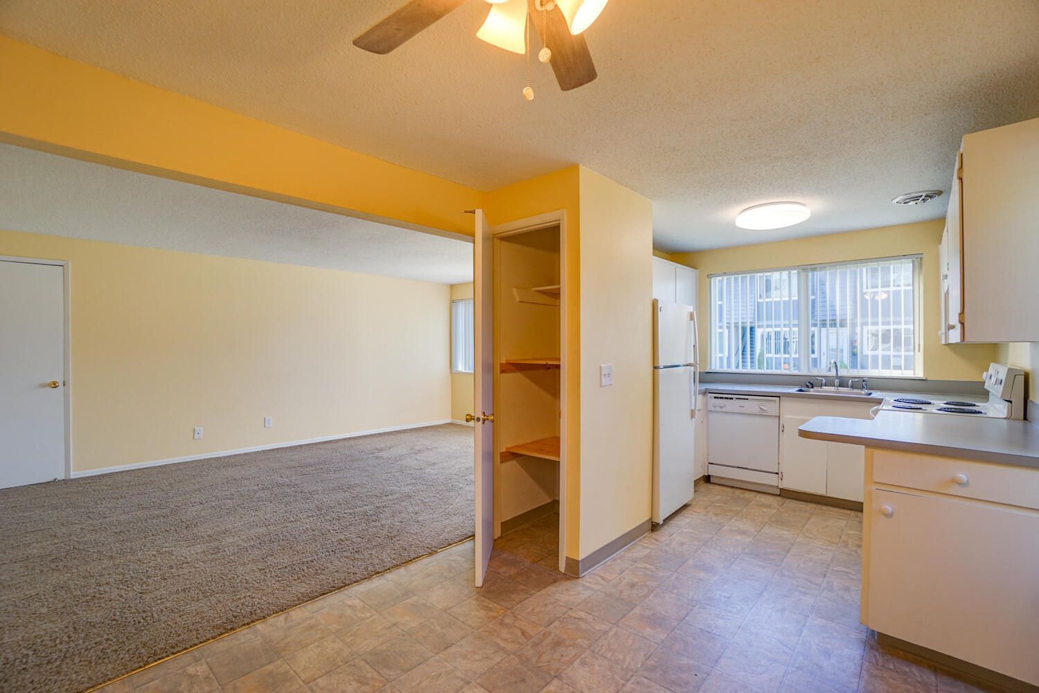 There is a ceiling fan in the kitchen and a closet in the living room.