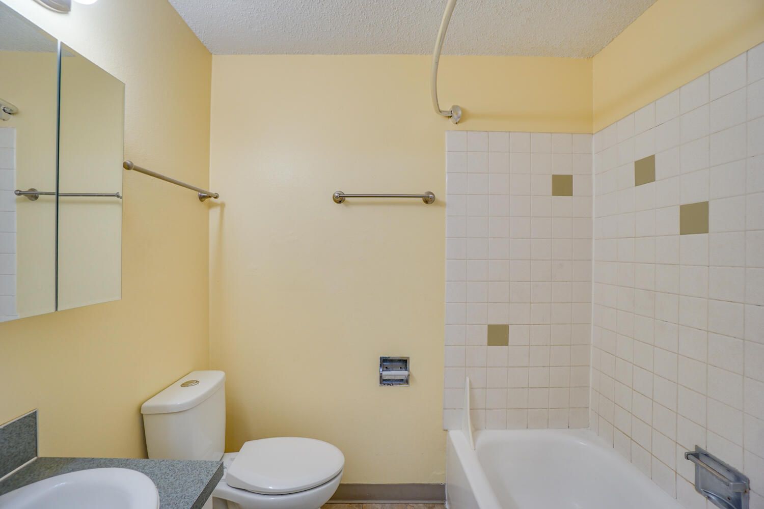 A bathroom with a toilet , sink , and bathtub.