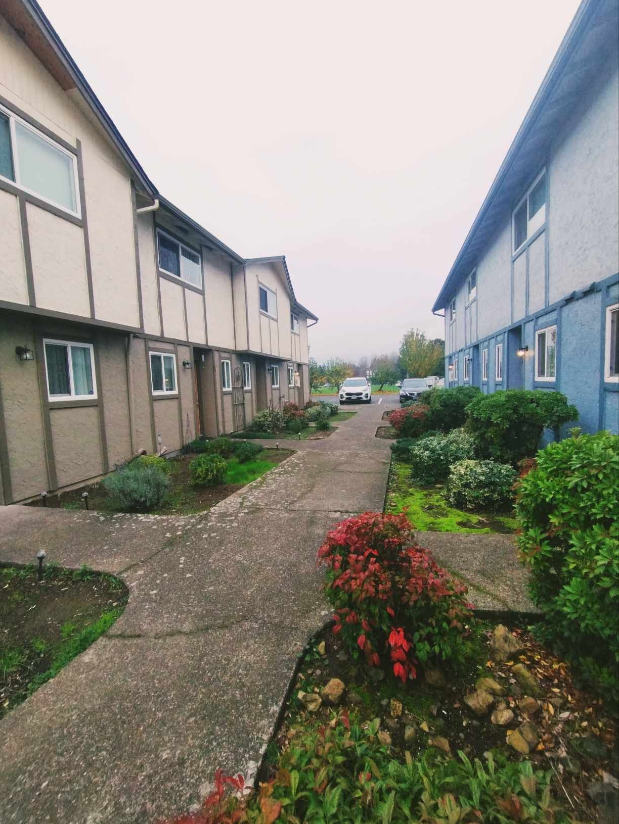 A row of apartment buildings with a walkway between them.