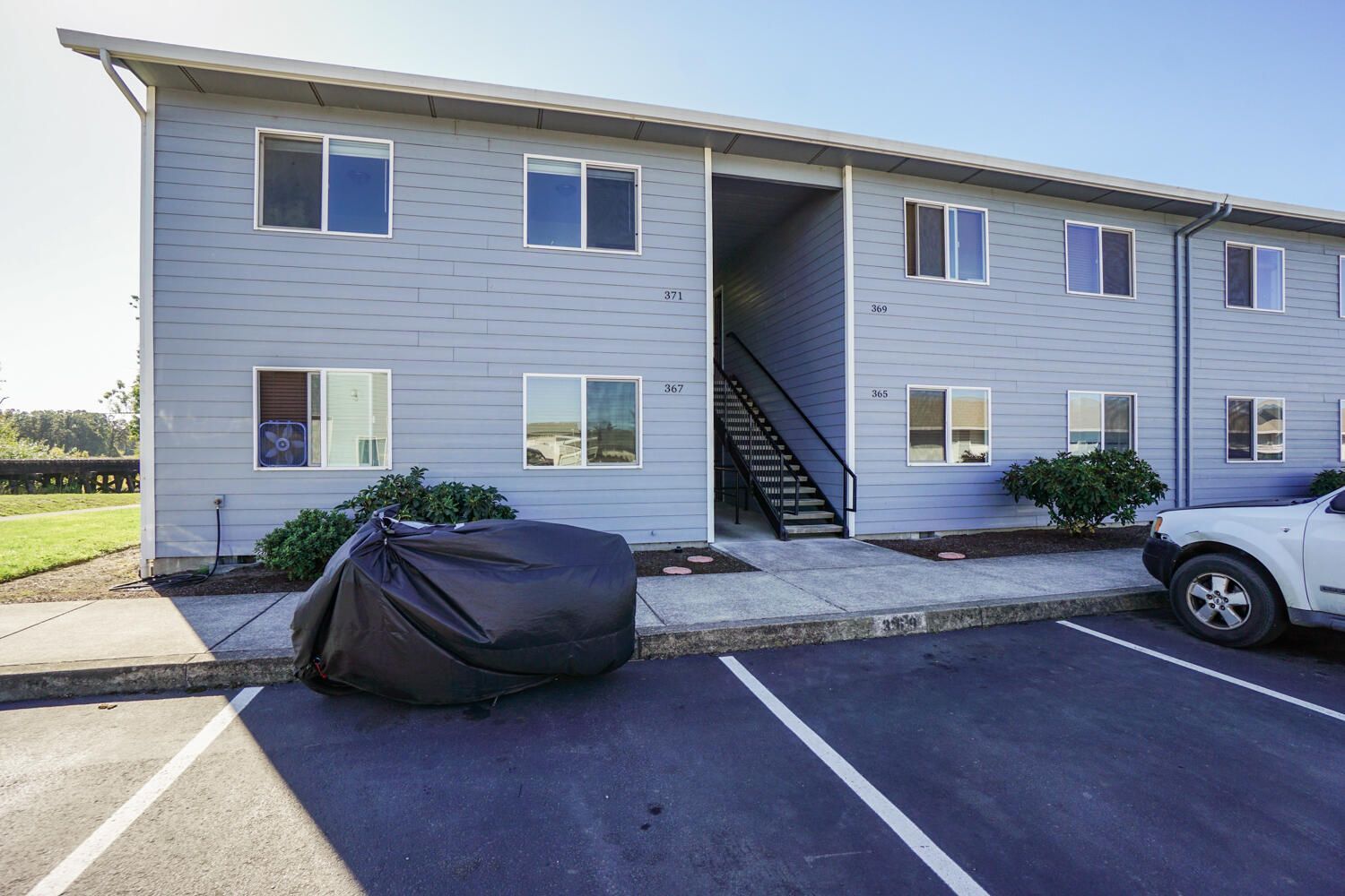 A motorcycle is parked in a parking lot in front of a building.