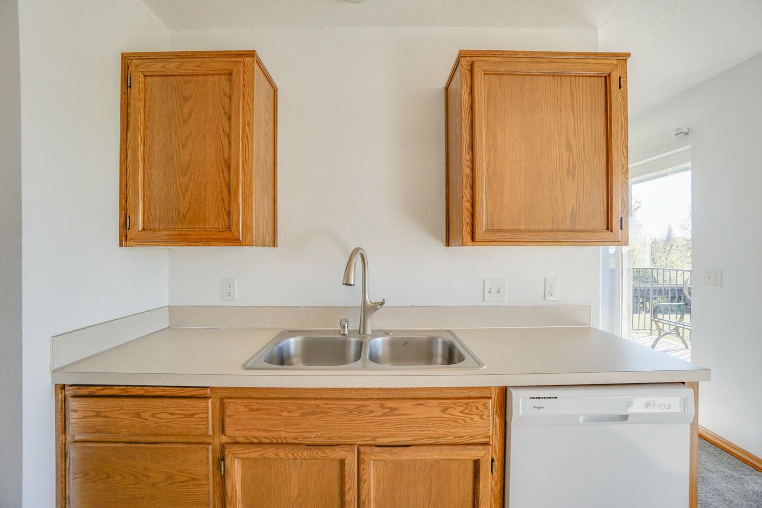 A kitchen with a sink , cabinets , and a dishwasher.