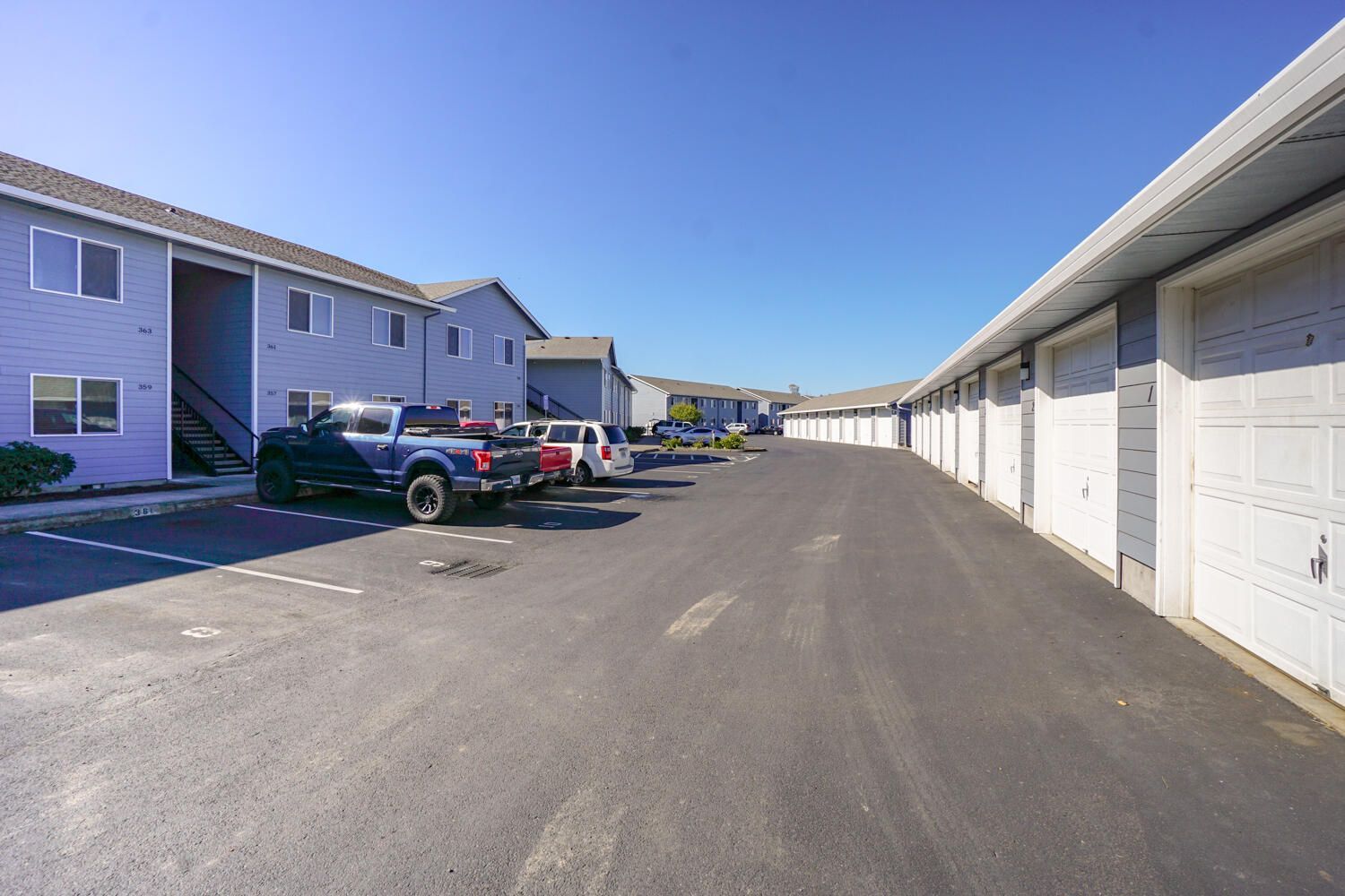 A parking lot with cars parked in front of a building