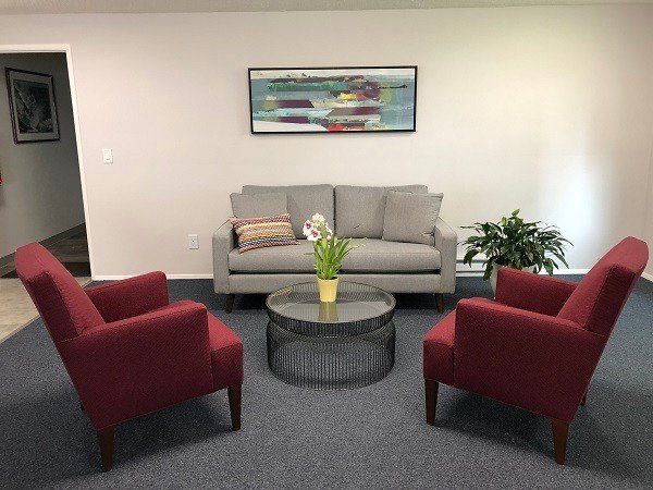 A living room with a couch , two chairs and a coffee table.