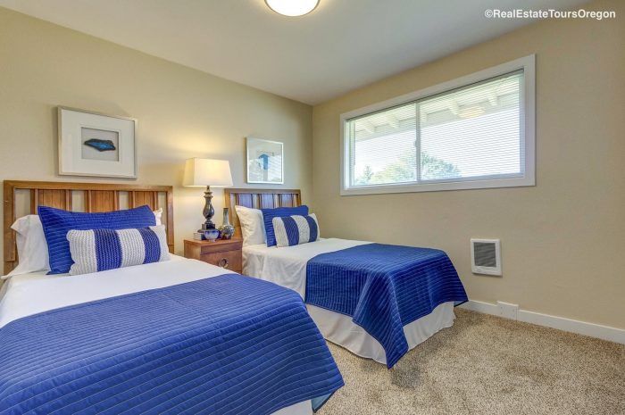 A bedroom with two twin beds and a window