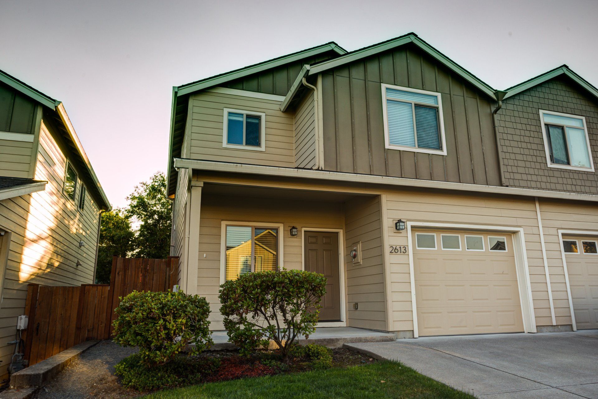A house with a garage and a fence in front of it