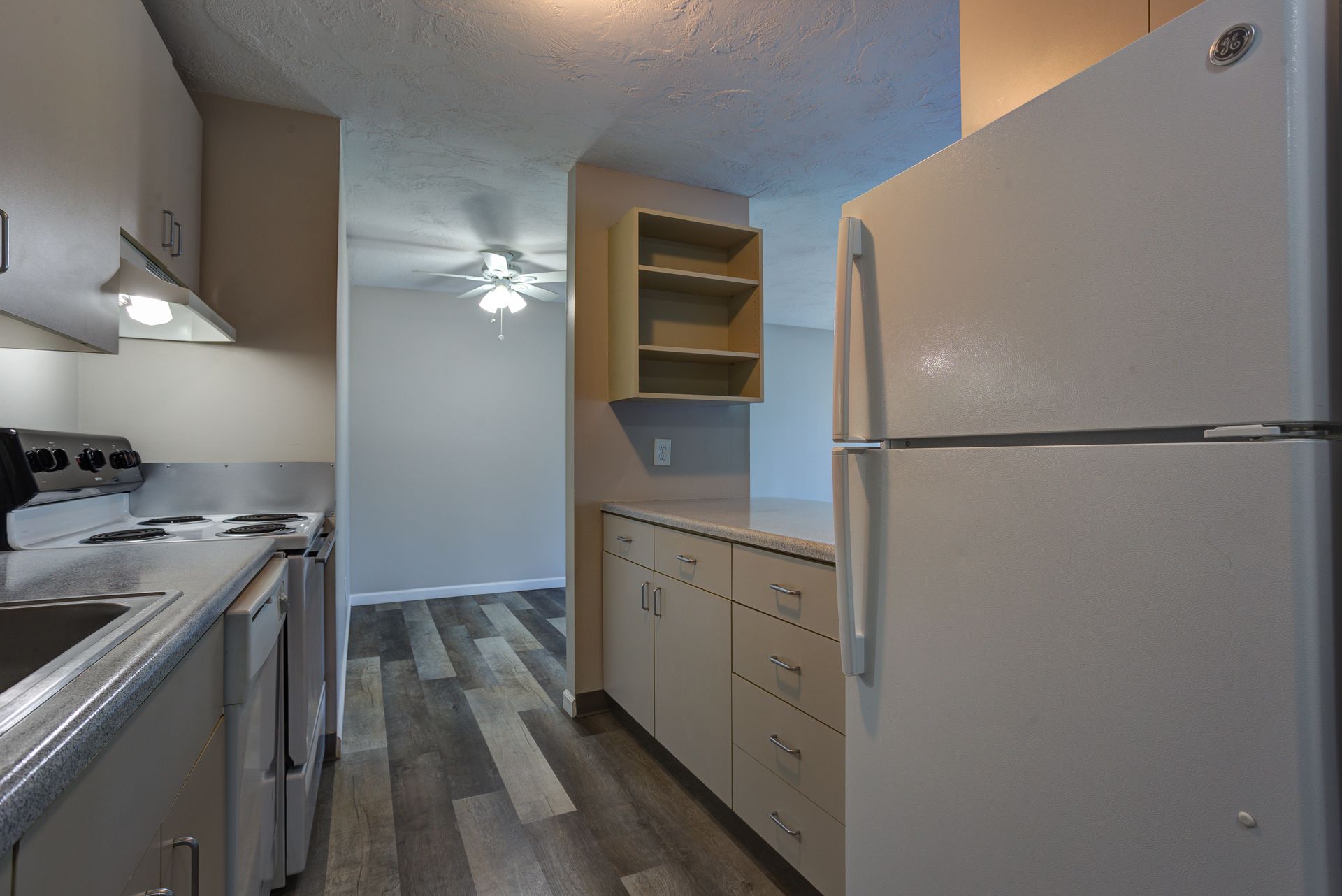 A kitchen with a refrigerator , stove and sink